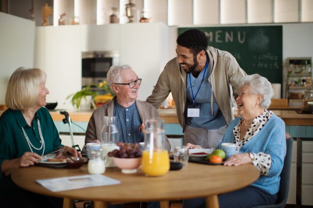 Group of cheerful seniors enjoying breakfast in nursing home care center